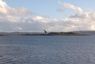 A seagull soaring above the Clyde by Craigendoran Pier with Ardmore Point in the background