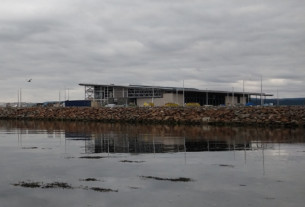 A seagull soaring above a calm river Clyde and the reflection of the new leisure centre.