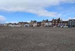 The barren grey site at the pierhead in Helensburgh is shown beneath cloudy blue skies
