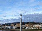 A seagull perched on top of a lamppost with Helensburgh riverside buildings in the background